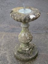 A weathered three sectional cast composition stone sundial with pierced gnomon and baluster shaped