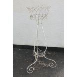A weathered cream painted wire work jardiniere stand with lattice detail and scrolled supports, 92