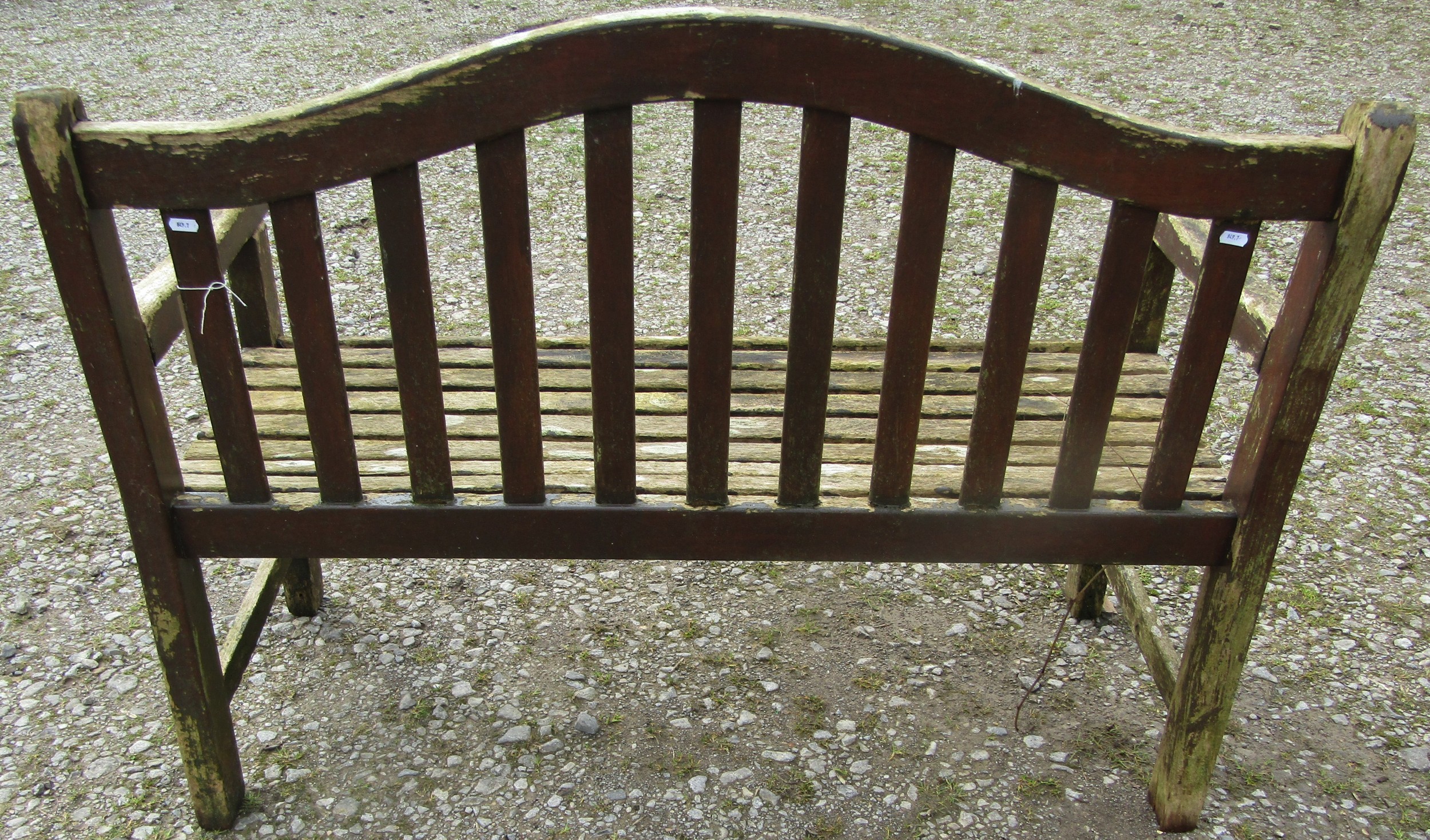 A weathered and stained teak garden bench with slatted seat and back beneath an arched rail, 120 cm, - Image 4 of 5