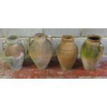 Four weathered terracotta jars, three with moulded loop handles, two with glazed interiors, slight