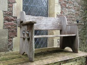 A weathered rustic hardwood two seat garden bench with simple pegged framework (will easily