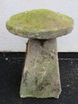 A weathered natural stone staddle stone with domed cap raised on a square tapered base 72 cm high