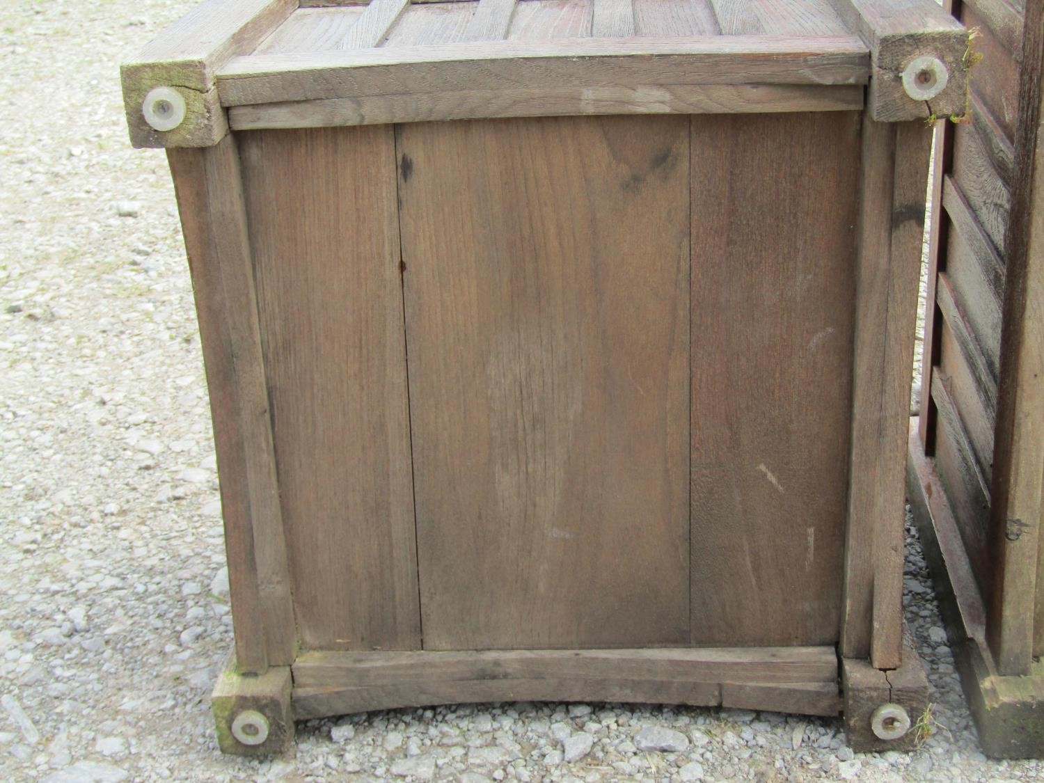 A pair of stained and weathered teak garden planters with facetted square cut supports and slatted - Image 6 of 7