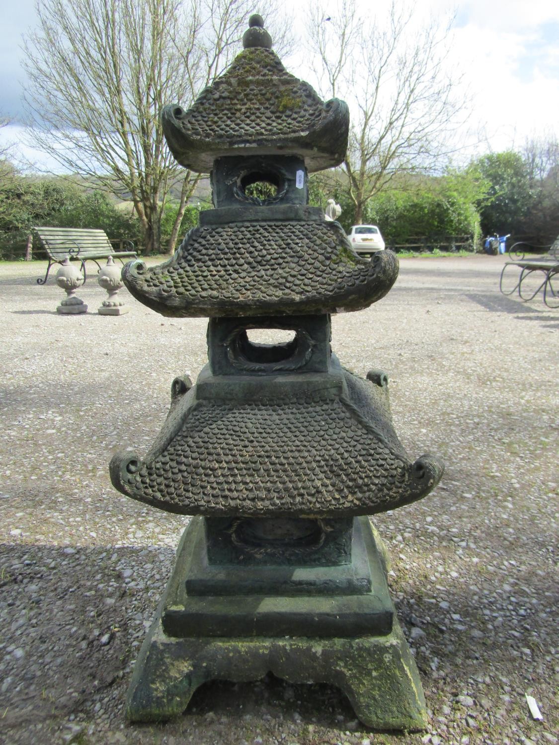 A weathered green painted cast composition stone sectional garden pagoda ornament, 105 cm high