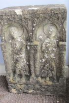 A weathered carved limestone panel in the old English / medieval style, decorated with stylised