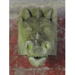 A weathered cast composition stone dragon mask fountain head approx 40 cm x 22 cm x 28 cm