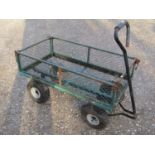 A useful four wheeled hand cart with rectangular green painted steel and lattice panelled body