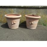 A pair of contemporary terracotta planters with moulded fruit motifs