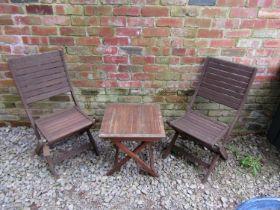 A weathered stained hardwood three piece folding terrace set with slatted detail, the table 50 cm
