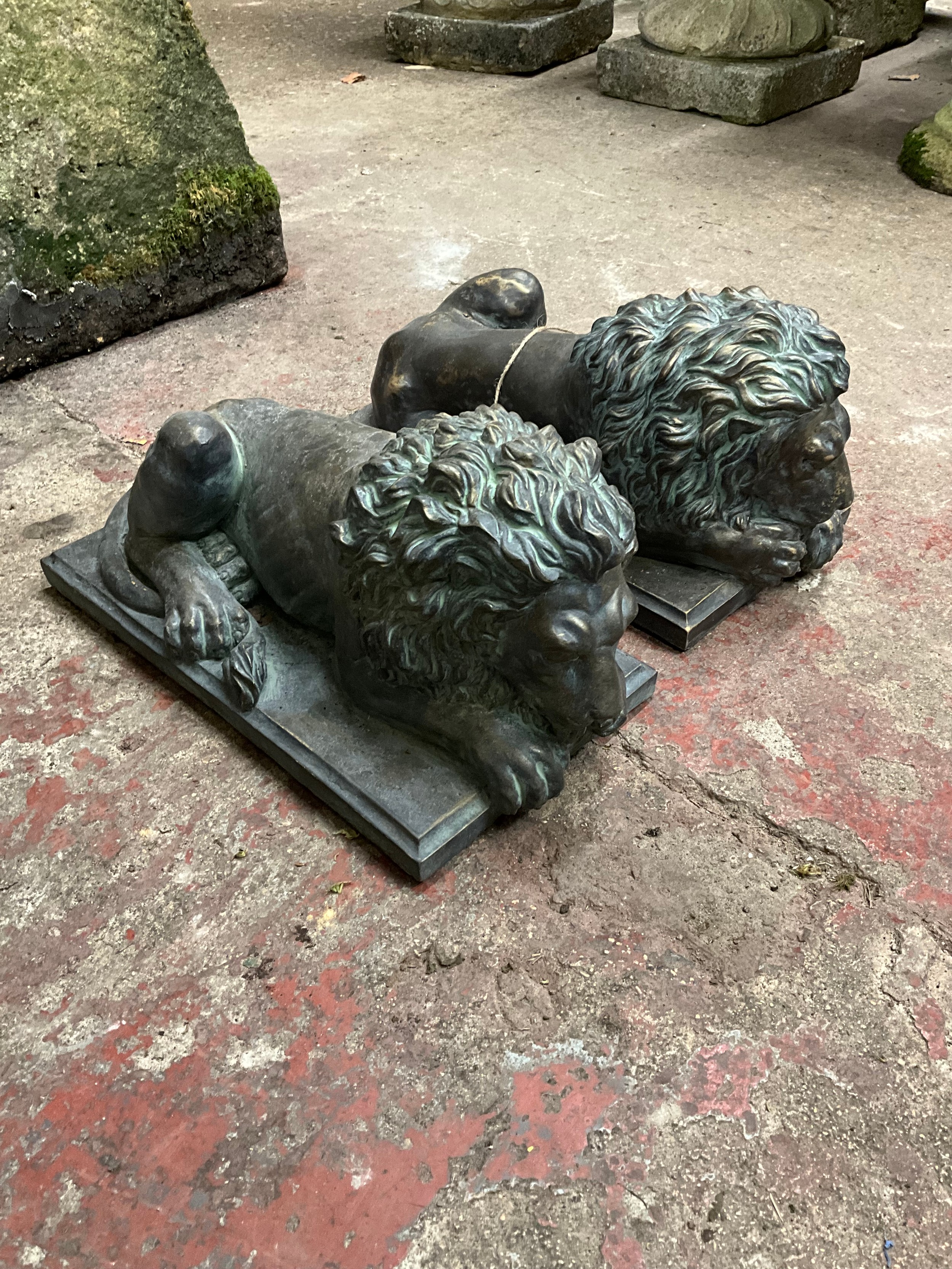 A pair of decorative cast simulated bronze recumbent lions, set on rectangular plinths, 20cm high, - Image 2 of 2