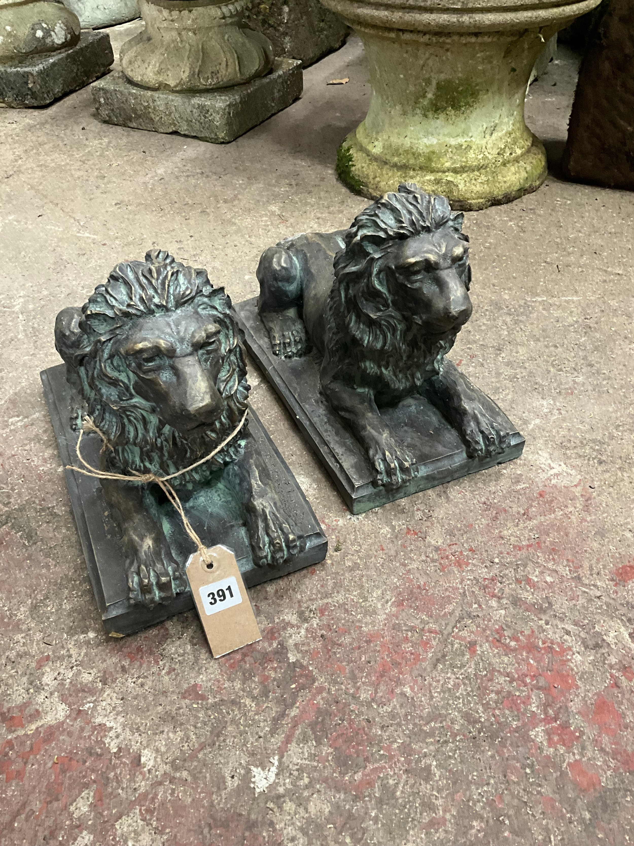 A pair of simulated, bronze models of recumbent Lions, with verdigris type finish, 27cm high, 39 x