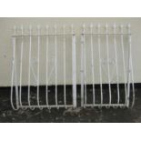 Two cream painted steel balcony rails with simple open scroll work detail and spear head finials,