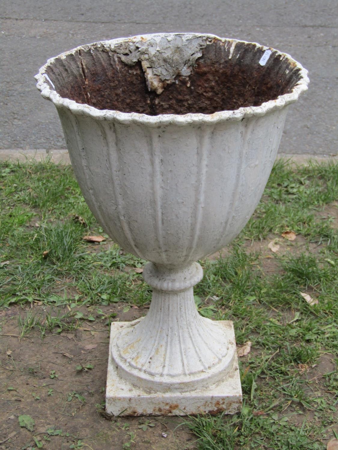 An old painted cast iron garden urn, the circular tapered bowl with crimped edge and fixed socle,