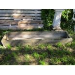 A weathered carved natural stone trough of rectangular form with slightly dished interior and
