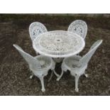 A weathered cream painted cast aluminium garden terrace table with decorative pierced circular top