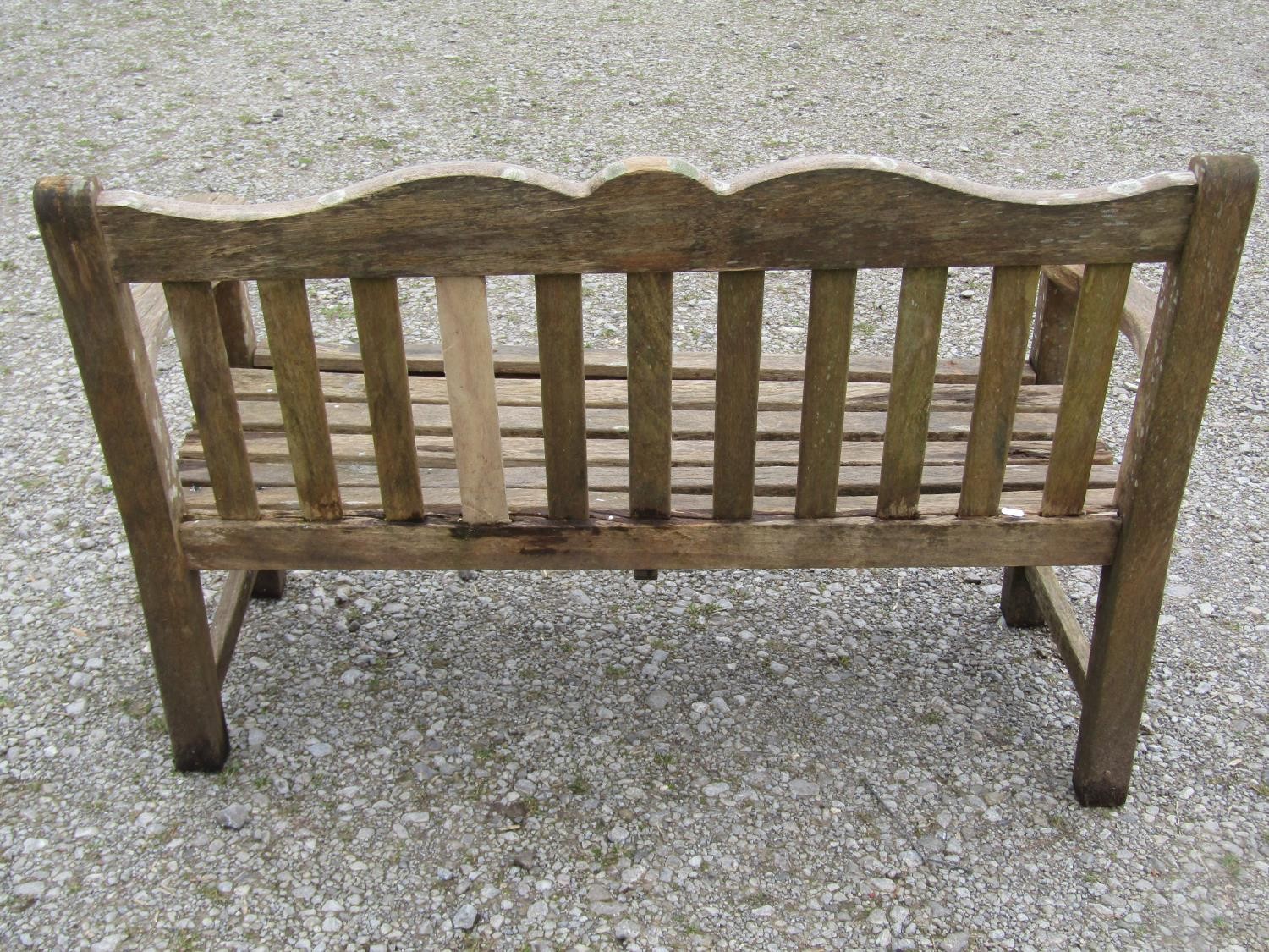 A Bridgman two seat weathered teak garden bench with slatted seat and back beneath a shaped rail - Image 3 of 3