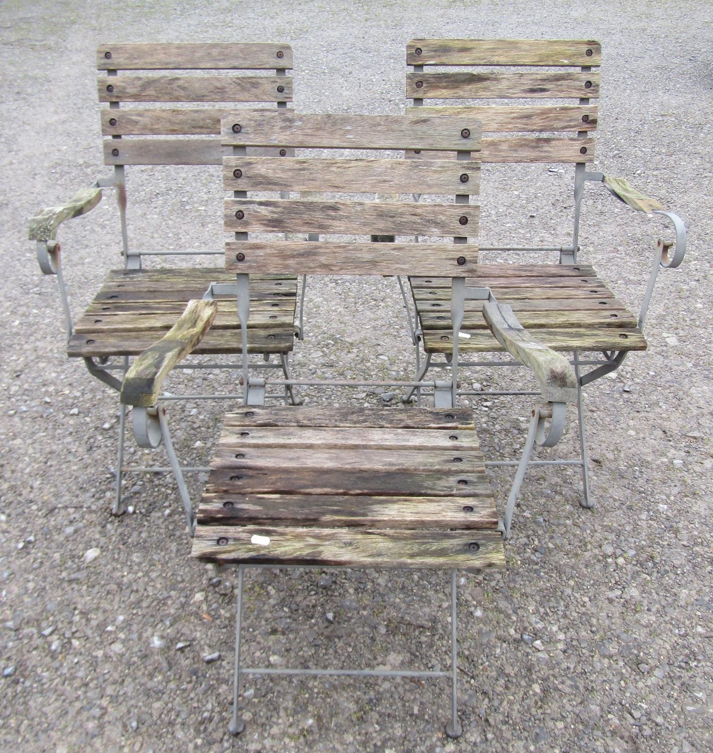 A set of three folding steel framed garden open armchairs with weathered timbered slats, 63 cm