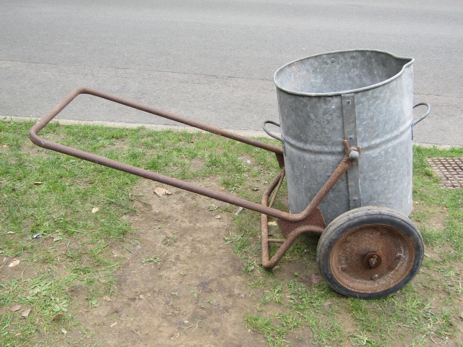 A vintage two wheeled water barrow, the iron frame supporting a cylindrical galvanised vessel