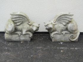 A pair of good quality cast composition stone pier ornaments in the form of Griffins set on