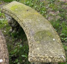 A weathered three-sectional cast composition stone garden bench, the curved slab seat with tongue