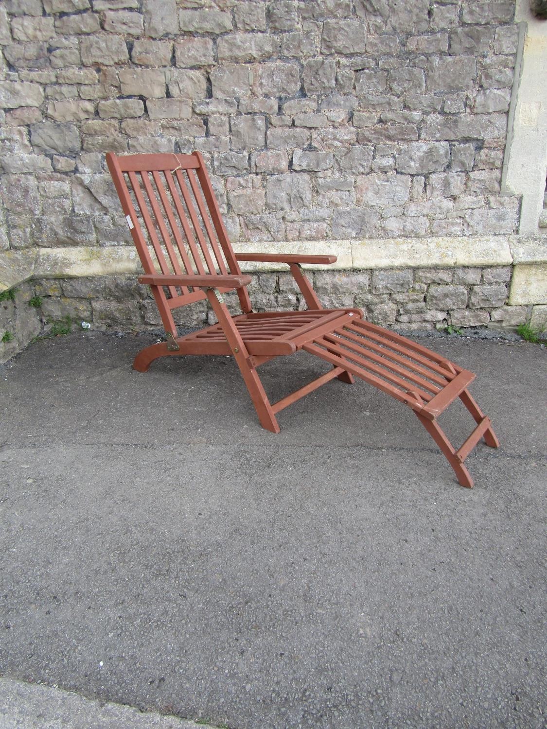 A contemporary stained hardwood folding steamer type chair with slatted seat, back and foot rest