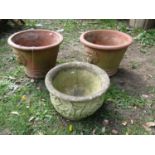 A pair of weathered terracotta garden planters of circular tapered form with lions mask detail 30 cm