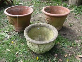 A pair of weathered terracotta garden planters of circular tapered form with lions mask detail 30 cm