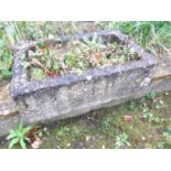A weathered cast composition stone rectangular garden trough with drainage hole, 22 cm high x 67
