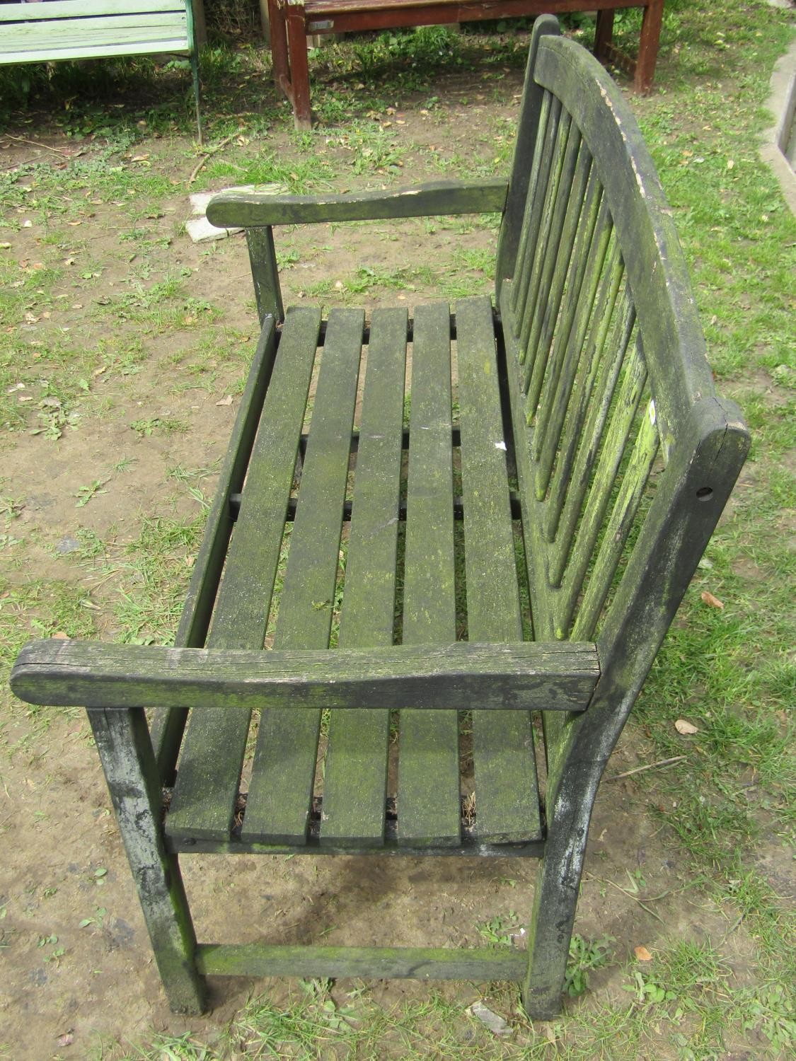 A weathered teak two seat garden bench with slatted seat and back beneath an arched rail 122 cm wide - Image 4 of 8