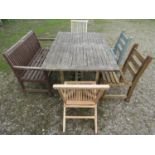An associated suite of garden furniture comprising a weathered teak table with rectangular slatted