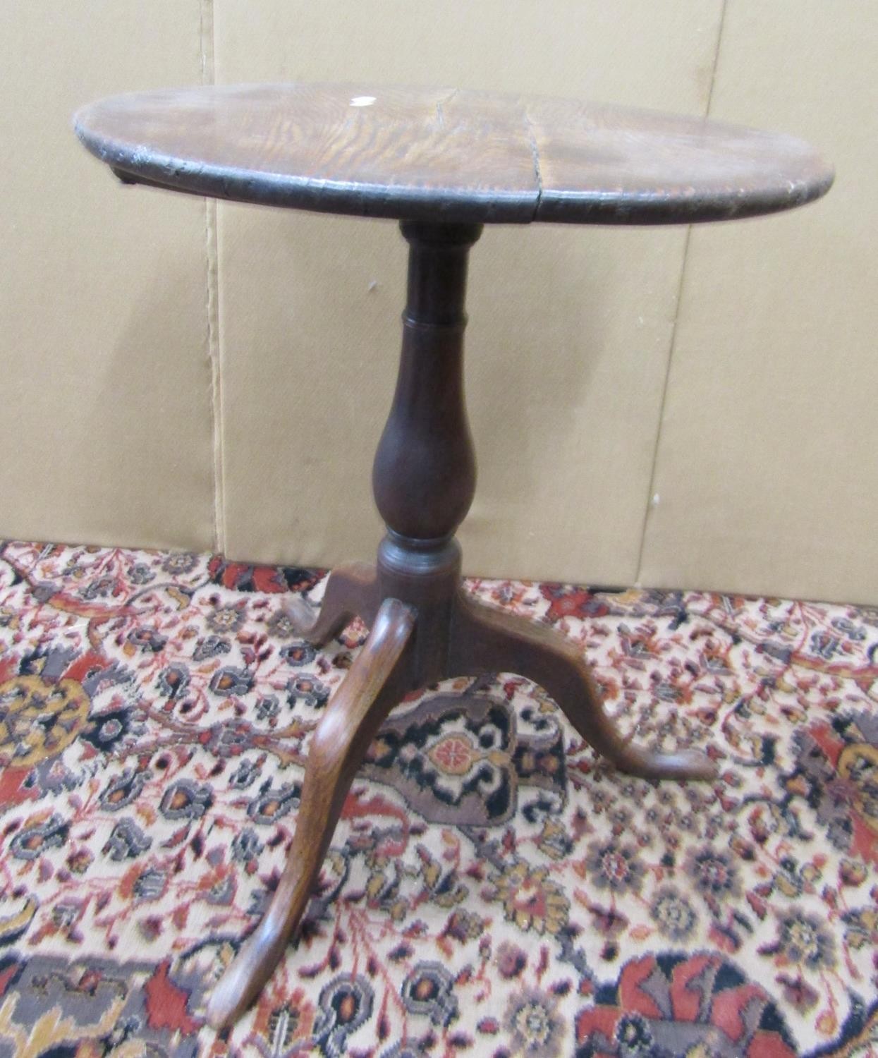 A Georgian cottage oak snap top table, the circular top 54cm diameter, raised on a turned pillar and