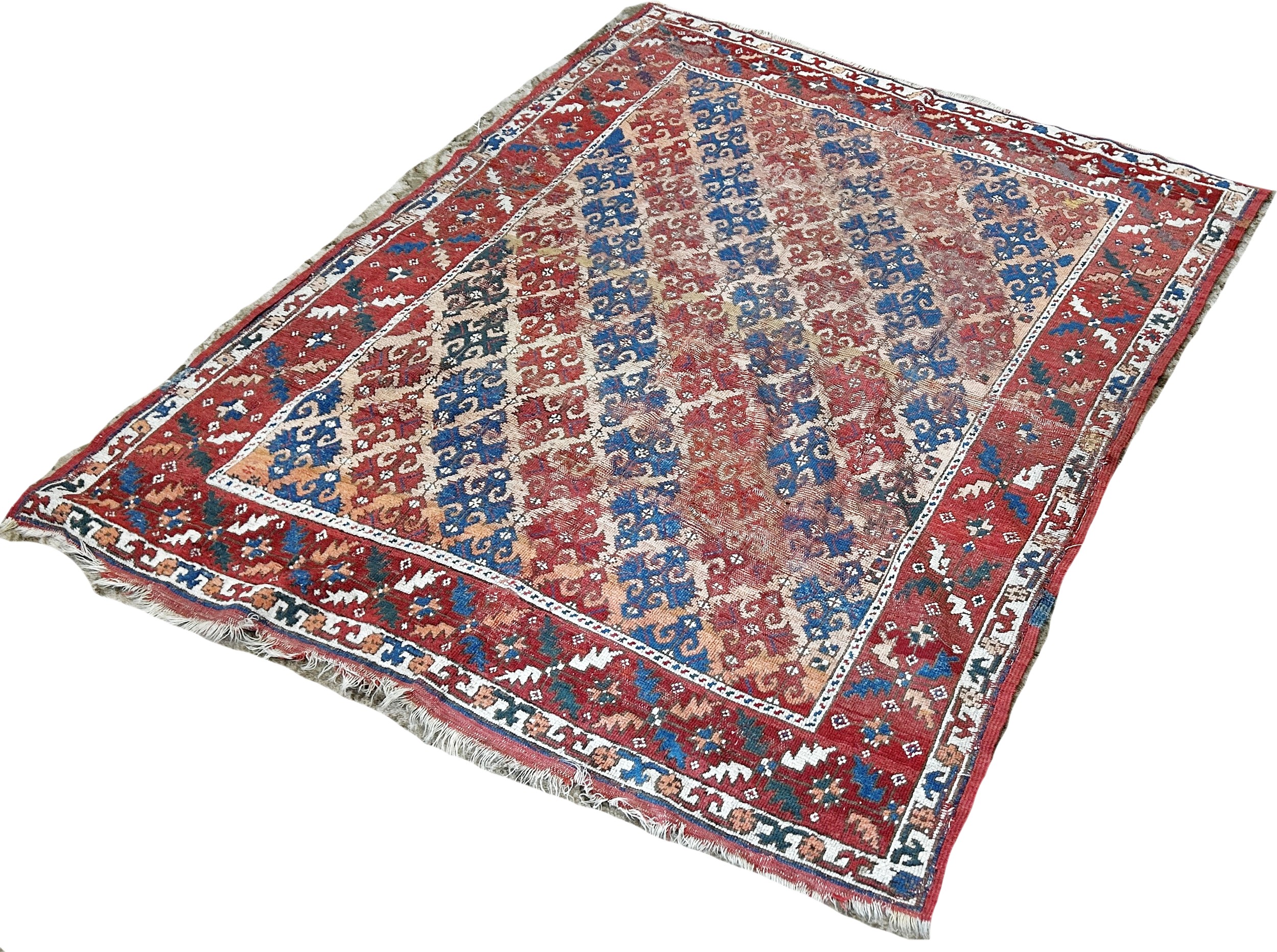 An old Persian rug with diagonal red and blue geometric patterns, worn in places, 163cm x 136cm - Image 3 of 3