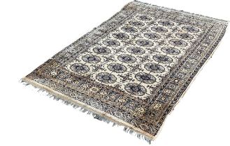 A Bokara style carpet, with three row of elephant foot blue guls on a beige ground, 185 x 130cm