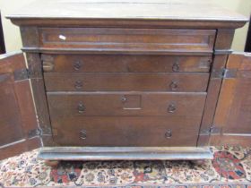 An 18th century oak enclosed chest of drawers, the front elevation presented as two doors with