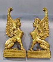 A symmetrical pair of decorative carved gilt-wood wall-hanging winged sphinx, each 43 x 18cm. From