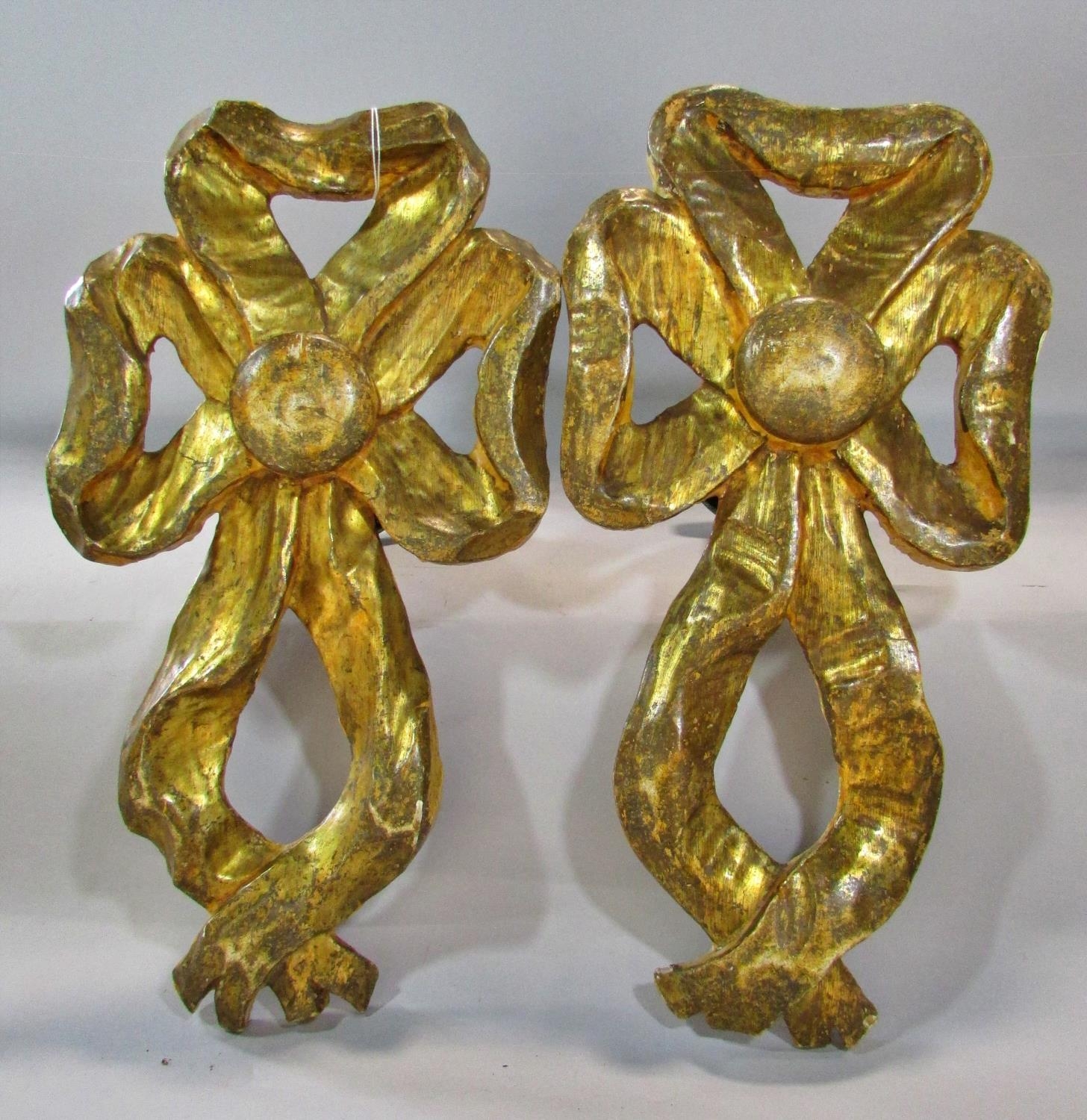 A pair of 19th century carved gilt wood wall mounted curtain tie back mounts, in the form of