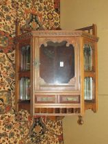 A late 19th century walnut hanging corner cupboard with mirrored recessed sides and spindle