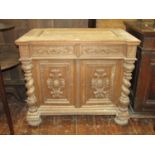 A 19th century oak side cupboard enclosed by two carved and panelled doors with two frieze drawers