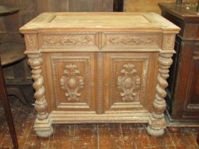 A 19th century oak side cupboard enclosed by two carved and panelled doors with two frieze drawers