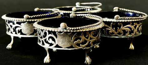 Four matching Victorian oval silver salt cauldrons with pierced filigree sides and loop handles,