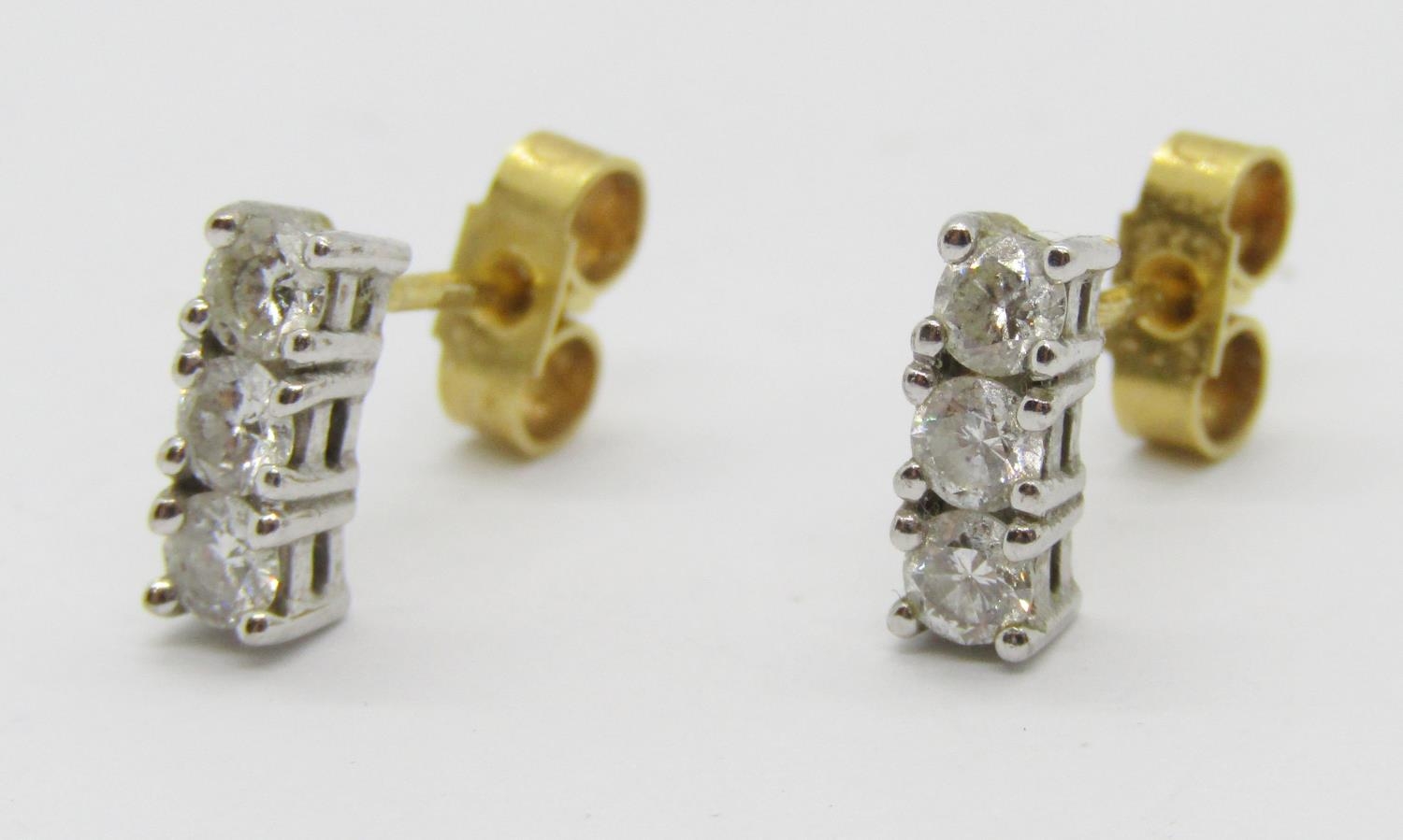 Pair of 18ct three stone diamond stud earrings, each stone 0.10ct approx, maker 'ATLd', London, 1.8g