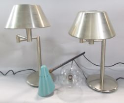 A pair of contemporary brushed steel bedside lamps with hinged extendable arm and brushed steel