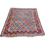 An old Persian rug with diagonal red and blue geometric patterns, worn in places, 163cm x 136cm