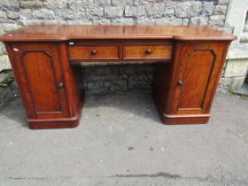 A Victorian mahogany inverted breakfront desk with two central drawers flanked by panelled