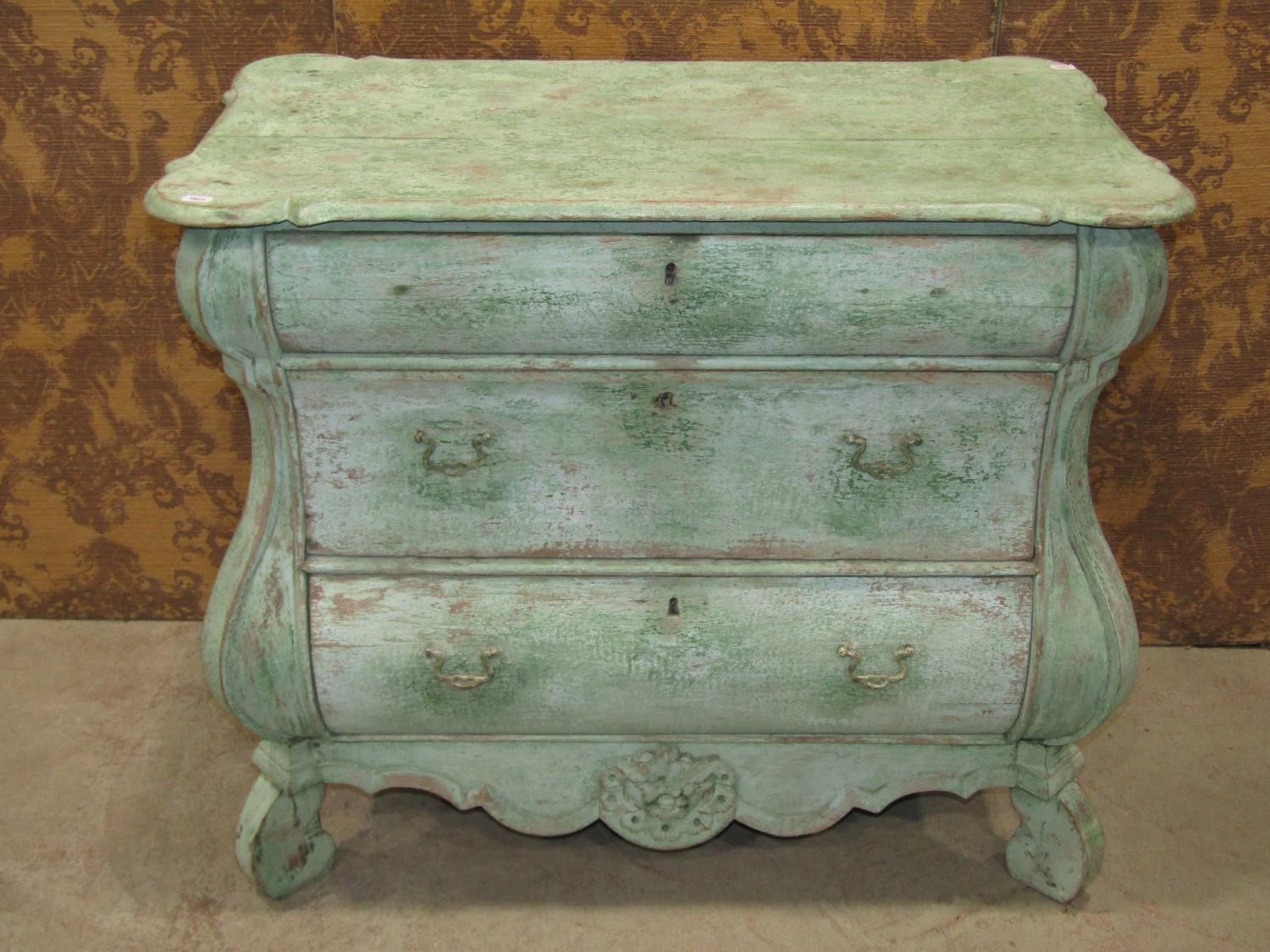 A small green painted and dry-scraped Dutch bombe chest of three drawers, 90cm wide x 50cm deep x