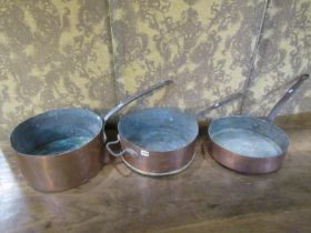 Three 19th century copper saucepans with heavy iron handles, average diameter 35cm