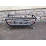 A simple good quality hand wrought iron fire basket on scrolled supports, 63cm x 31cm