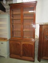 A Victorian mahogany library bookcase enclosed by a pair of arched panelled doors, the upper section