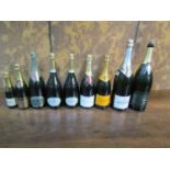 Nine empty champagne and other bottles with labels for decoration