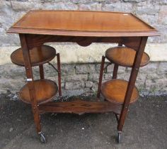 A patent oak tea trolley with folding cake racks, together with a pegged oak occasional table